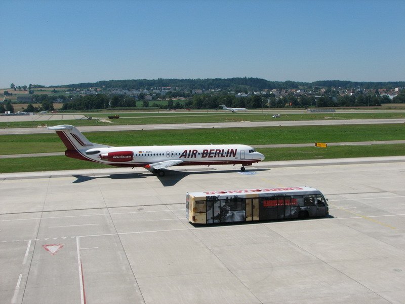 Air Berlin, D-AGPK, Fokker 100. Wer ist schneller, das Flugzeug, oder der  Emmentaler Kse  Bus ? Foto von der Zuschauerterrasse am 14.7.2005.