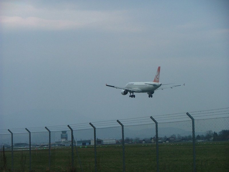 Airbus A-320 von Freebird im Landeanflug.
Im Hintergrund der Tower mit Terminal.