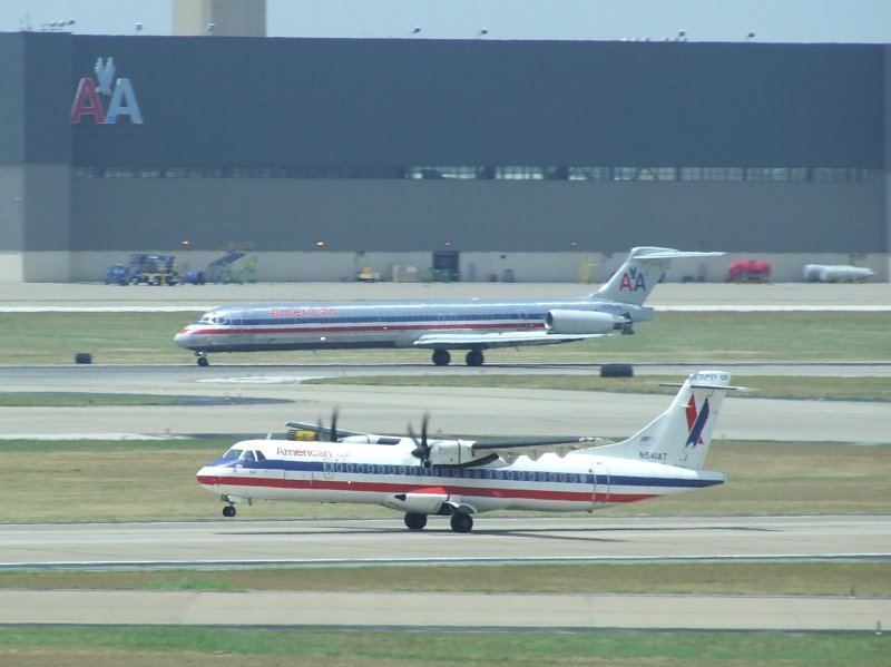 Eine ATR 42 der American Eagle beim Start, whrend im Hintergrund eine MD-83 der American nach der Landung abbremst. (Dallas Fort Worth, 24.07.2009)