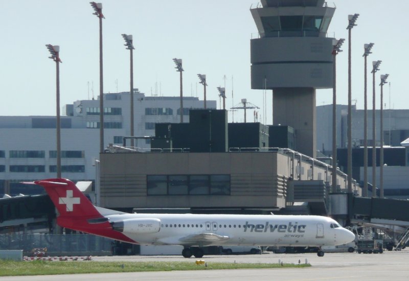 Fokker 100 der Helvetic mit neuer Lackierung auf dem weg zum Terminal. Im Hintergrund der Tower von Zrich. (7.8.2008)
