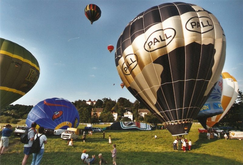 Juni 2002. Hessentag in Idstein. Einer der Programmpunkte war ein Massenstart von Heissluftballons. Einige sind bereits in der Luft, andere sind kurz vor dem abheben und noch andere liegen mit einer leeren Hlle noch am Boden (digitalisiertes Dia)