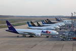 FedEx, Boeing B777-FS2, N885FD, parkt mit anderen Frachtflugzeugen vor den Frachthallen in Köln-Bonn (CGN/EDDK) am 24.11.2019.