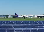 Boeing 737-700 der Hamburg International (D-AHIB) beim Start Richtung Ibiza; im Vordergrund zu sehen ist das Solarkraftwerk am Flughafen Saarbrcken, das mit 4 MW Leistung den Strom fr 2.000 Haushalte in der saarlndischen Landeshauptstadt produziert und damit eines der weltgrten Solarkraftwerke ist.