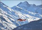 Agusta A109SP Da Vinci der Rega mit der Registrierung HB-ZRR dreht über dem Flughafen Samedan ab, vor der Kulisse des Piz Bernina, dem höchsten Berg und einzigen Viertausender der Ostalpen.
