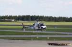 Hubschrauber Typ Aerospatiale AS-350 B mit Kennung D-HENA setzt zur Punktlandung auf die bereitstehende Rollplattform an. Aufname am Flughafen Neubrandenburg-Trollenhagen vom 28.08.2014. 