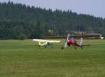 PZL 104 Wilga 35, D-EWRC, auf dem Weg zum Segelflugstart auf dem Flugplatz Rudolstadt-Groschwitz (EDOK), 26.7.2014. Im Hintergrund D-EOXQ nach der Landung.