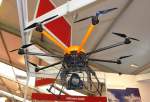 Multicopter, ausgerstet fr Foto-/Filmaufnahmen. Die Kamera steht, genauso wie die Drohne, in stdigem Kontakt zum Piloten. Das aufgenommene Video/Bild wird live auf einem Ausgabemonitor in der Hand des Piloten angezeigt. Foto: ILA Berlin 2012 