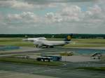 Die Boeing 747 der Lufthansa im Vordergrund rollt Richtung Runway 25R, auf der gerade eine 747 der Lufthansa aufsetzt.(04.06.05)