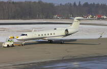 ein Privatjet wird in Friedrichshafen von der Parkposition zum Gate gezogen, aufgenommen am 26.01.2013 in FDH